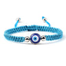 Turquoise knotted cord bracelet with a round blue eye and silver tone beads