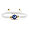 White knotted cord bracelet with one round blue eye and gold tone beads