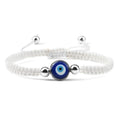 White knotted cord bracelet with one blue eye and silver tone beads