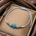 Turquoise evil eye cord bracelet with pale blue cord, faceted side beads and gold tone spacers