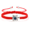 Red knotted cord bracelet with a silver tone turtle and blue eye in its shell