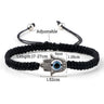 Black braided Hamsa bracelet with measurement annotations around the band, hand charm and eye