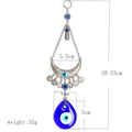 Silver tone crescent suspended between chains with coin charms and a blue teardrop eye pendant, with measurement and weight annotations