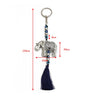 Silver tone elephant with blue eye beads, a dark blue tassel and a split ring, shown with measurement arrows