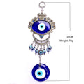 Oval blue eye in a floral frame above a crescent, eye bead fringe and round blue pendant, with measurement and weight annotations