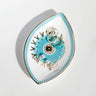 Turquoise sunburst eye tray holding rings and earrings, viewed at an angle