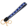 Navy loop keychain with six almond-shaped blue eyes, white borders, a black tab and gold tone attachments.
