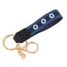 Navy loop keychain with blue borders, three round eye motifs, a black end tab and gold tone attachments.