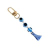 Light blue evil eye keychain with three round beads, a light blue tassel and a gold tone clip, arranged diagonally on white.