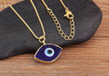 Dark blue evil eye pendant necklace with its gold tone lobster clasp and extension chain displayed beside the pendant.