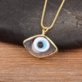 Close-up of the Grey necklace option, with a smoky grey pendant face, white and blue eye center and gold tone border and chain.