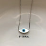 White marquise evil eye pendant with a blue center on a silver tone chain, shown with an 8 × 16 mm annotation.