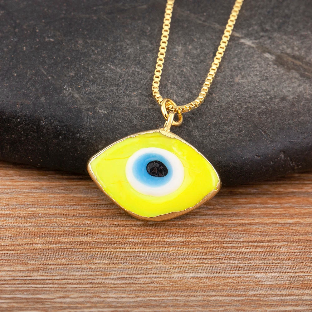 Close-up of the Yellow necklace option, with a white and blue eye center and gold tone pendant border and chain.