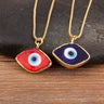Red and dark blue eye-shaped necklace pendants with blue and white centers, gold tone borders and chains.