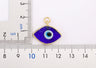 Wide view of a dark blue eye-shaped pendant beside two rulers marked in centimeters.