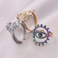 Three evil eye rings at different angles, showing the gold tone and silver tone bands beside the rainbow ring's oval face.