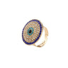 Gold tone evil eye ring with concentric blue and clear accents on a white background