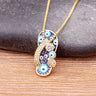 Gold tone slipper pendant necklace with blue and white eye motifs, a curved strap and three round side details