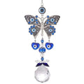 Butterfly evil eye suncatcher with patterned silver tone wings, two blue heart charms and a clear faceted ball on white
