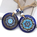 Two blue evil eye wall hangings showing gold tone floral scrolls and a turquoise mandala with repeated eye motifs