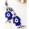 Two blue Hamsa evil eye pendants with beaded cords and three bead drops, arranged on a white surface
