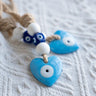 Blue heart evil eye pendants with white eye surrounds, dark blue cube beads and tan rope
