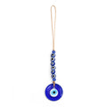Round blue evil eye pendant beneath a row of six blue eye beads and two blue faceted accents