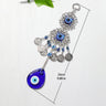 Teardrop evil eye wall hanging laid flat beside a length guide labeled 24 cm and 9.88 in.