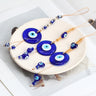 Three round blue evil eye hangings with silver tone spacers, oval eye drops or blue heart drops