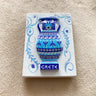 White rectangular magnet with a raised blue and turquoise two-handled vase, patterned bands and CRETE lettering.