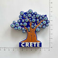 Tree-shaped magnet with an orange trunk, blue eye-pattern canopy and CRETE base beside ruler markings.