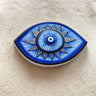 Blue and white almond-shaped eye magnet with radiating lines and triangular points, shown at an angle.