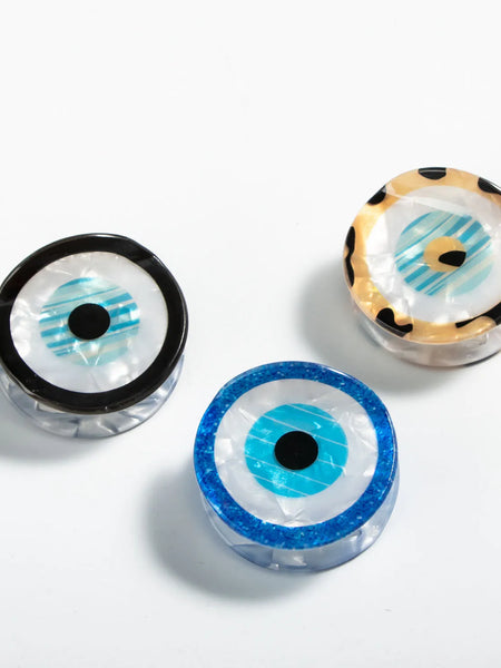 Three round evil eye hair claw clips with black, blue and tan spotted rims