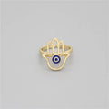 Gold tone openwork Hamsa hand ring with a circular blue eye detail in the palm