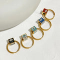 Five gold tone hoop earrings with black, white, turquoise, blue and red evil eye cube beads in a diagonal arrangement