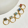 Five gold tone hoop earrings with black, white, turquoise, blue and red evil eye cube beads in a diagonal arrangement