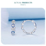 Blue evil eye and clear heart hoop earrings shown from the front and side on a pale blue background