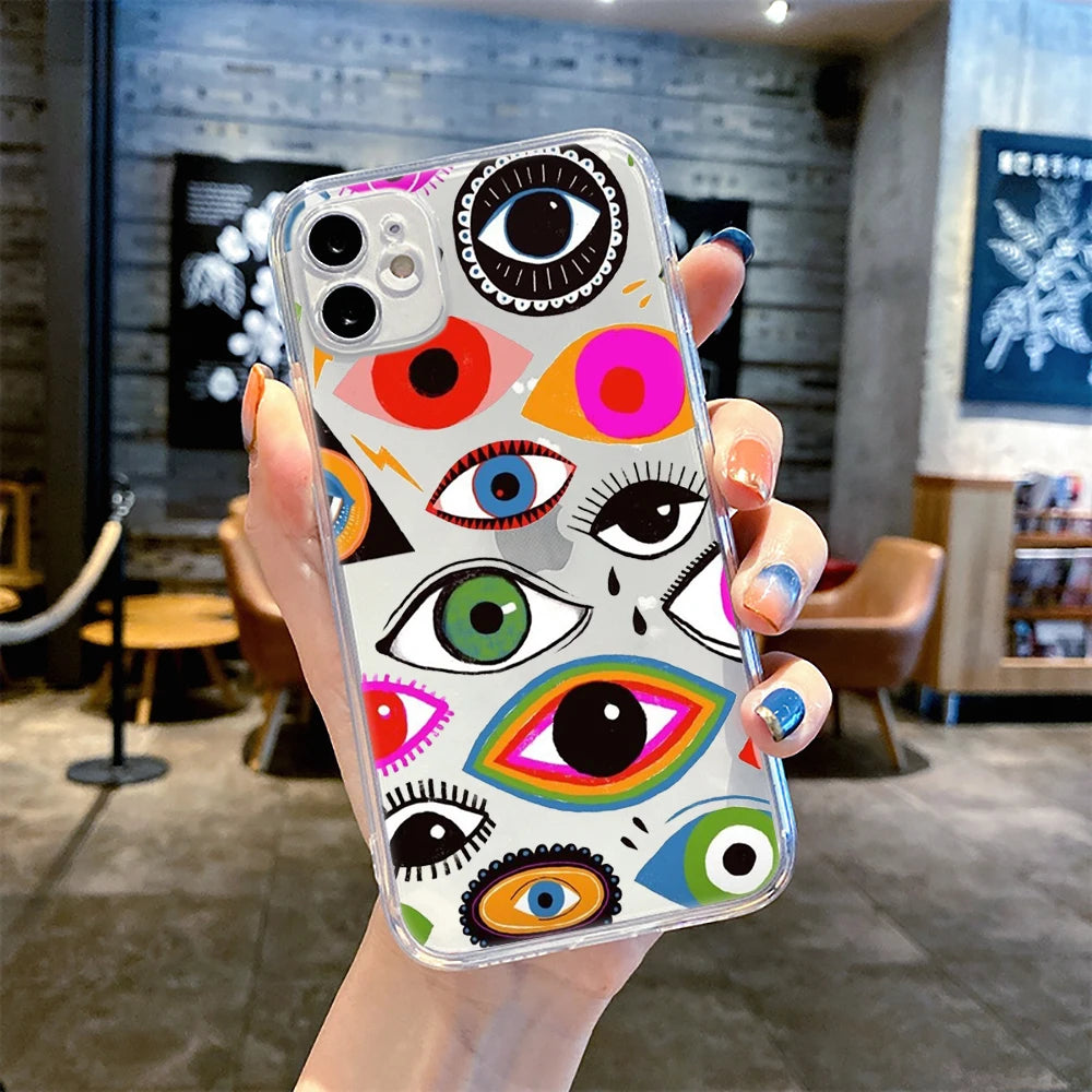 Clear iPhone case with a multicolored eye collage and rainbow-outlined eye, shown on a phone held in one hand.