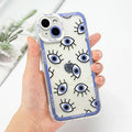 Clear iPhone case with blue eyes, black lash outlines and a blue lettered border, held in a hand