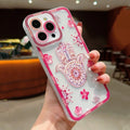 Pink floral Hamsa phone case held at an angle, with a mandala in the palm and scattered blossoms