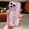 Pink floral Hamsa phone case shown from the back with a patterned palm, scattered flowers and a pink border