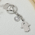 Reverse of the silver tone hamsa keychain, showing a dotted hand charm with an opening and a round charm with radiating lines.