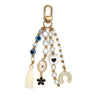 White and black beaded keychain with a horseshoe charm, oval eye pendant, black flower, heart motif bead and cream tassel