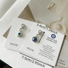 Blue and white evil eye keychain charms on cards, with a 3.4 cm label beside the blue charm and 7.5 cm labels along its card.