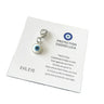 White evil eye keychain charm with a light blue ring, dark center and silver tone lobster clasp on a card against a white background.