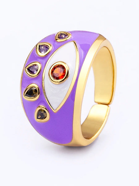 Purple evil eye ring at an angle, showing a white eye, orange-red center, five teardrop accents and an open band.