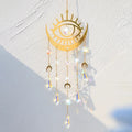 Gold tone eye and crescent suncatcher with three crescent charms and five pointed faceted drops.
