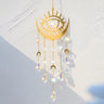 Gold tone eye and crescent suncatcher with three crescent charms and five pointed faceted drops.
