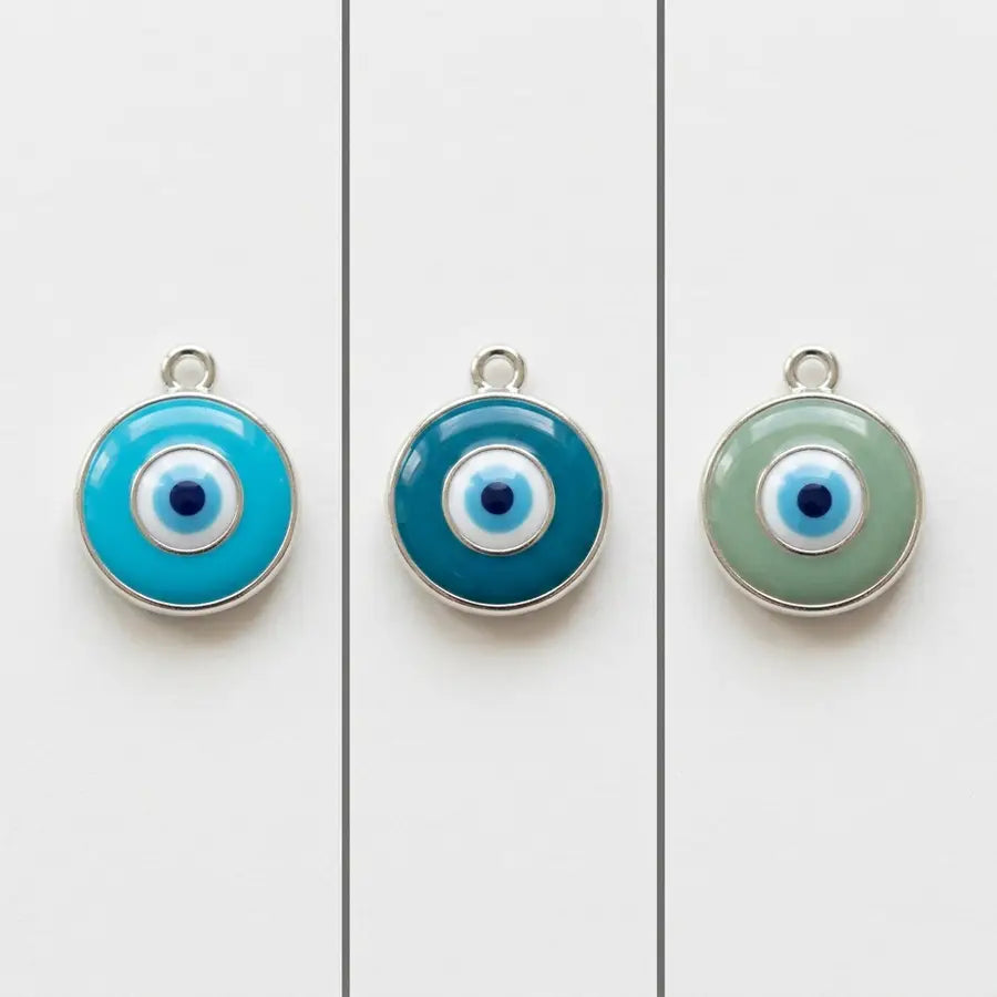 Three equal evil eye charms in turquoise, teal, and green arranged side by side with neutral dividers.