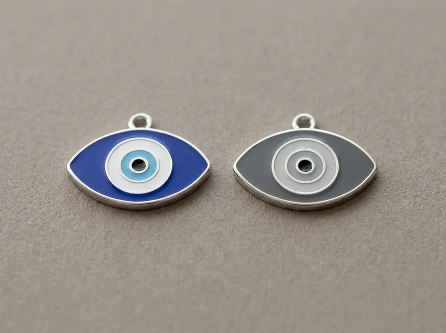Contemporary blue and grey evil eye charms shown side by side for a color comparison; verify against the final visible image.